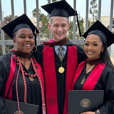 three students at graduation